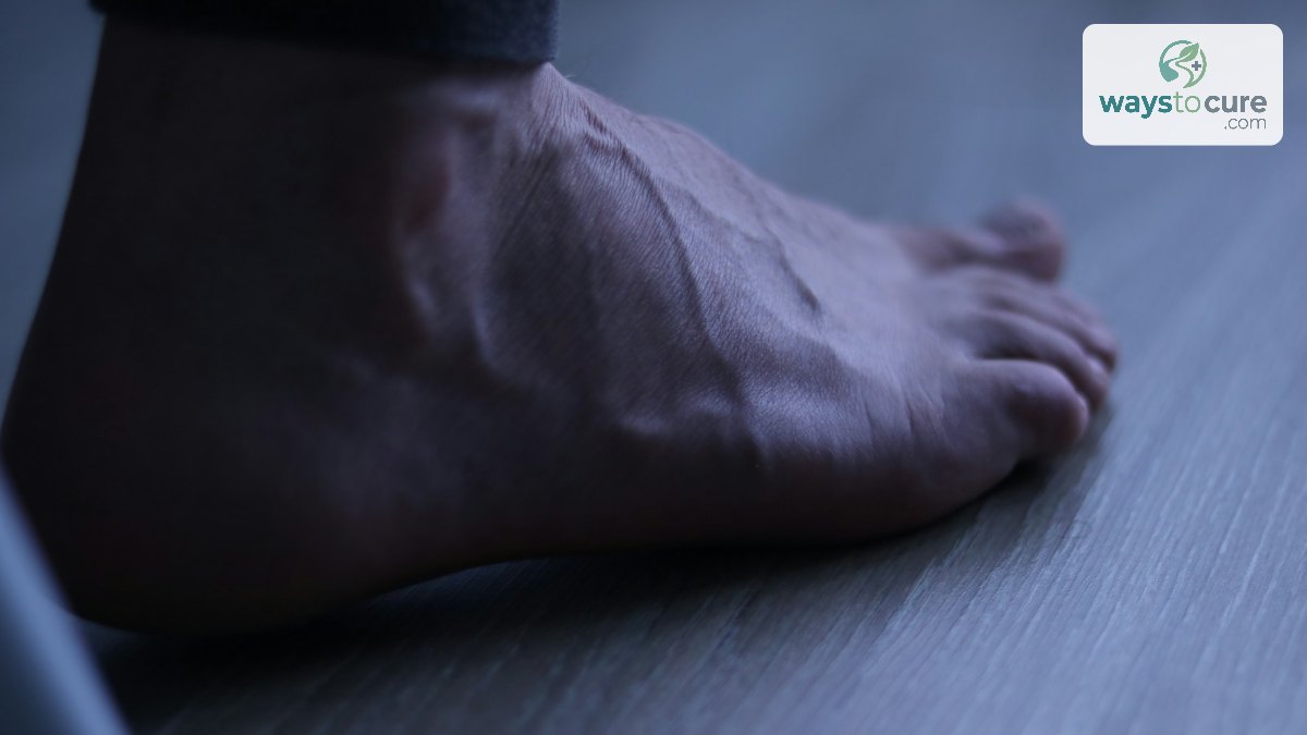 A bare foot resting on a wooden floor in soft light