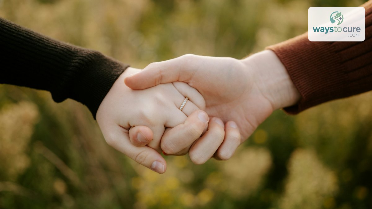 Close-up of two hands clasped together against a soft green background